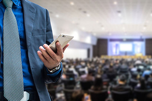 man in suit holding his phone looking at notifications